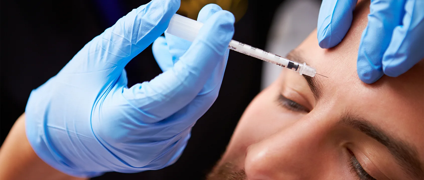 man receiving botox in forehead